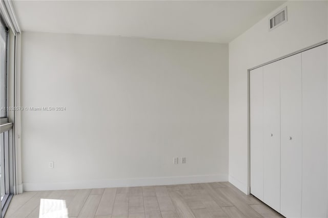 unfurnished bedroom featuring light hardwood / wood-style floors and a closet