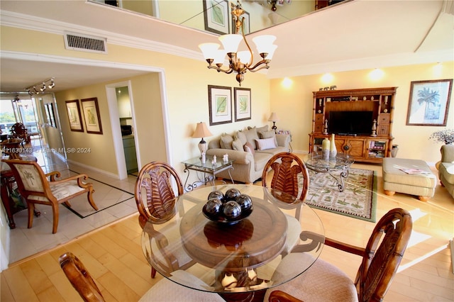 dining area with wood-type flooring, a notable chandelier, and crown molding