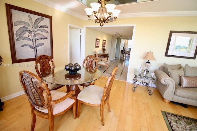 dining room featuring a notable chandelier, ornamental molding, and light wood-type flooring