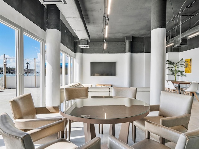 dining area featuring track lighting and a high ceiling