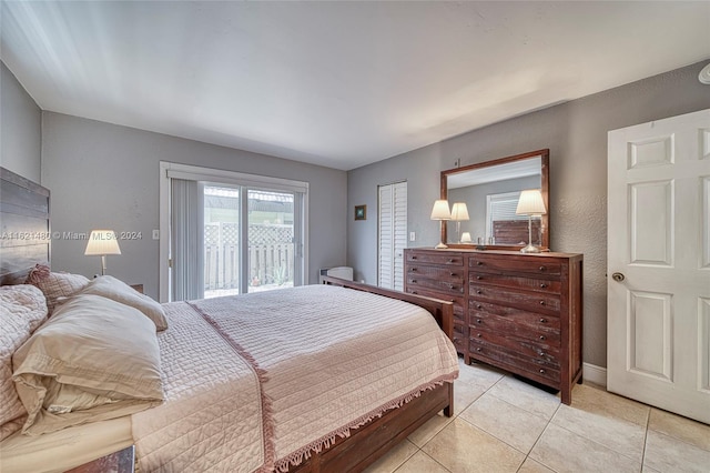 bedroom with access to exterior, a closet, and light tile patterned floors