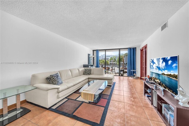 tiled living room with expansive windows and a textured ceiling