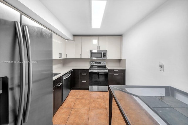 kitchen featuring white cabinets, stainless steel appliances, and light tile patterned floors