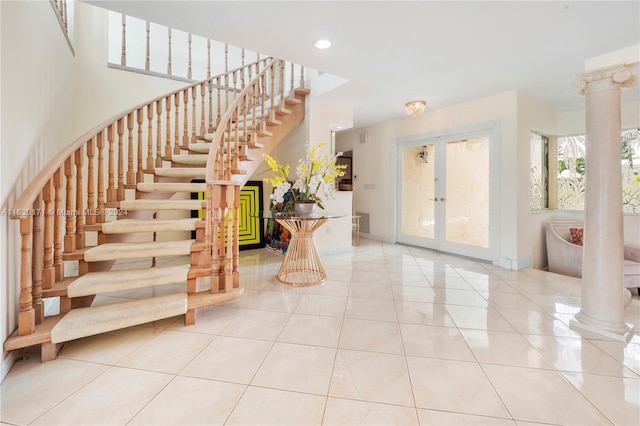 entrance foyer featuring light tile patterned flooring, french doors, and decorative columns