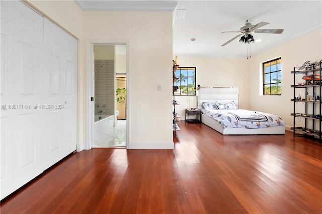 unfurnished bedroom featuring dark wood-type flooring, connected bathroom, ornamental molding, and ceiling fan