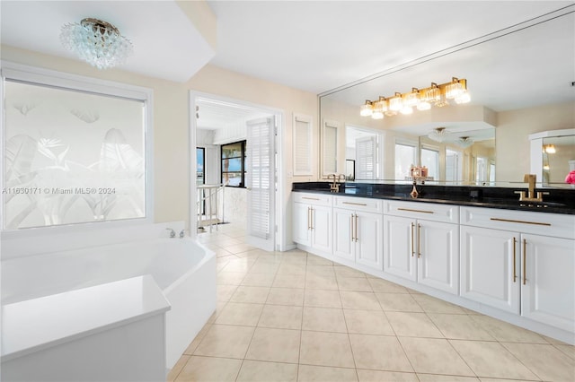 bathroom featuring double vanity, a tub, tile patterned floors, and an inviting chandelier