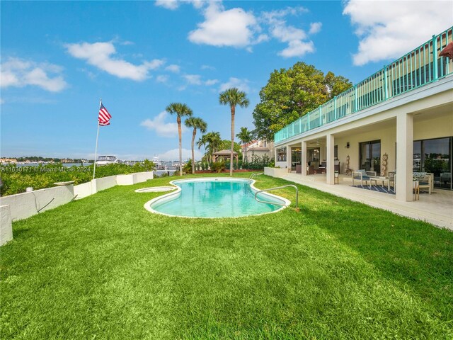 view of pool with a patio area and a lawn