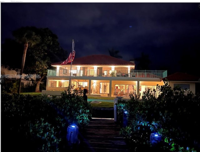 back house at twilight with a balcony