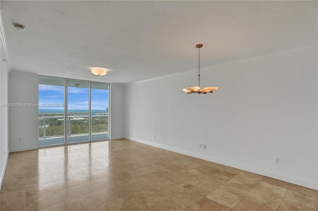 empty room with expansive windows and a chandelier