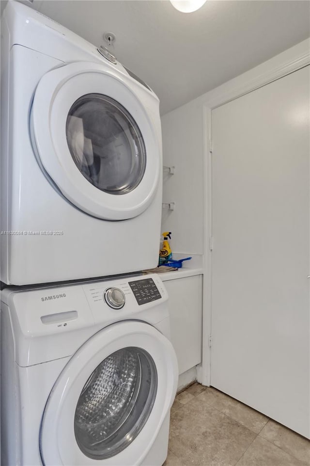 laundry area featuring light tile patterned floors and stacked washer / drying machine