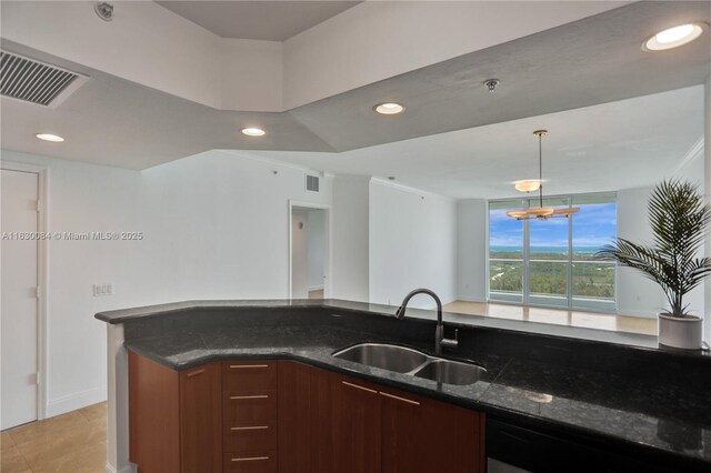 kitchen featuring sink, decorative light fixtures, appliances with stainless steel finishes, a notable chandelier, and kitchen peninsula