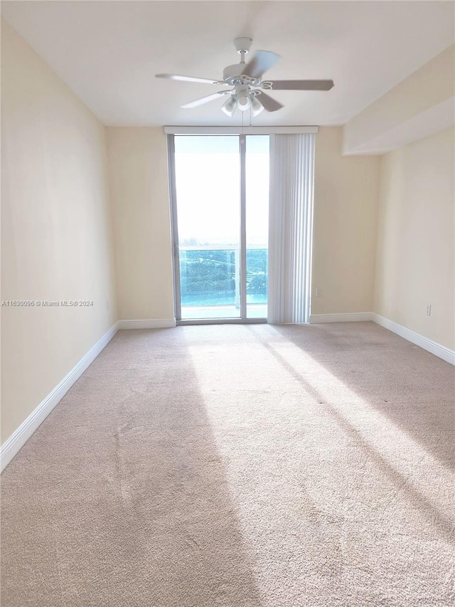 carpeted empty room featuring ceiling fan