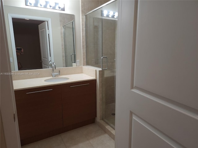 bathroom featuring vanity, tile patterned flooring, and an enclosed shower