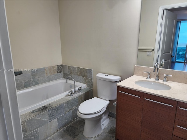 bathroom with tile patterned flooring, tiled tub, toilet, and vanity