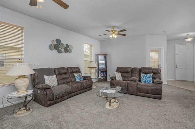 living room with ceiling fan, light carpet, and a textured ceiling