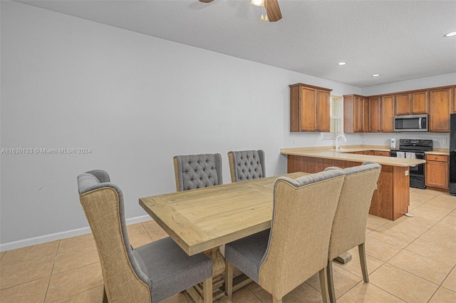 tiled dining room featuring sink, a textured ceiling, and ceiling fan