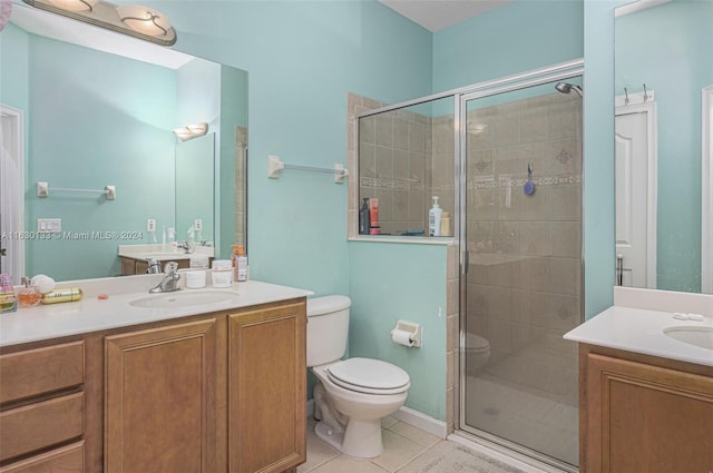 bathroom with toilet, vanity, tile patterned floors, and a shower with shower door