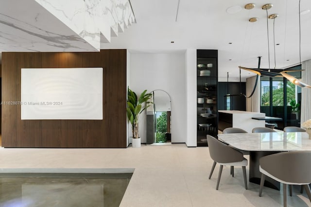 dining area with a healthy amount of sunlight and wooden walls