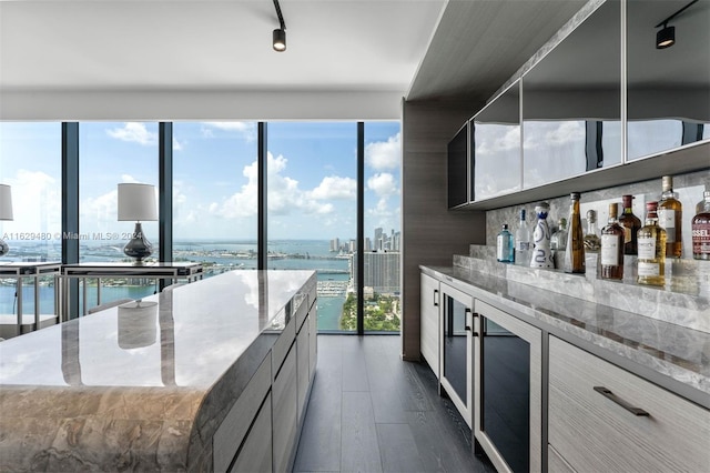 788 NE 23rd St Unit 4601, Miami, FL 33137 - kitchen featuring modern cabinets, track lighting, beverage cooler, a water view, and light stone countertops