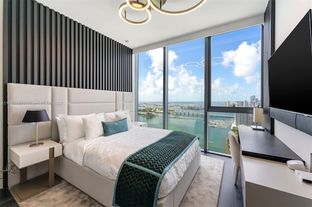 bedroom featuring a notable chandelier, expansive windows, and access to exterior