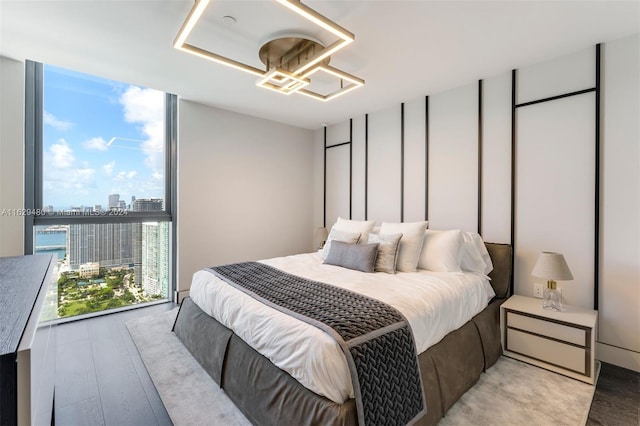 bedroom with a wall of windows and light wood-type flooring