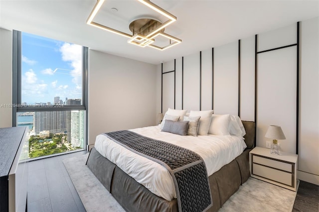788 NE 23rd St Unit 4601, Miami, FL 33137 - bedroom featuring a wall of windows, light wood-style floors, a city view, and a chandelier