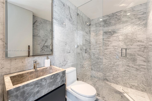 bathroom featuring vanity, a shower with door, tile walls, and toilet