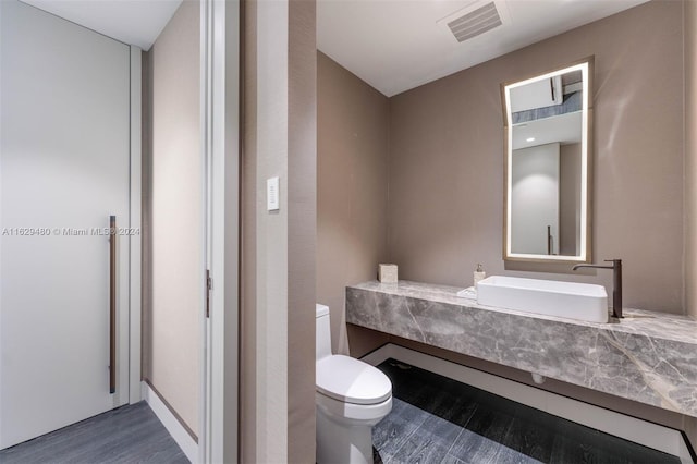 bathroom featuring vanity, hardwood / wood-style flooring, and toilet