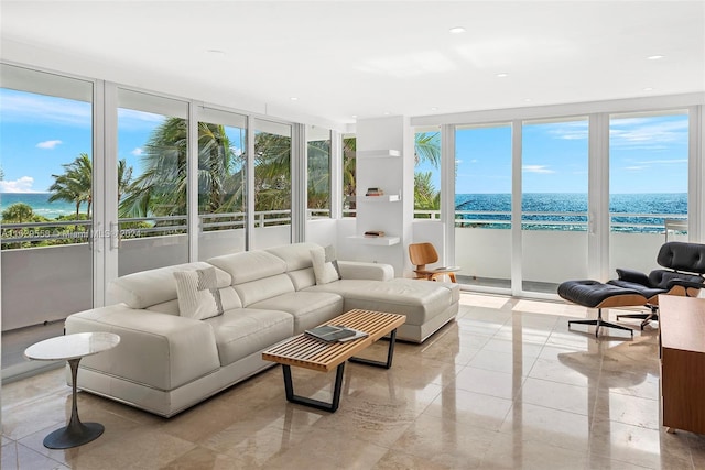 sunroom featuring a water view, a beach view, and plenty of natural light