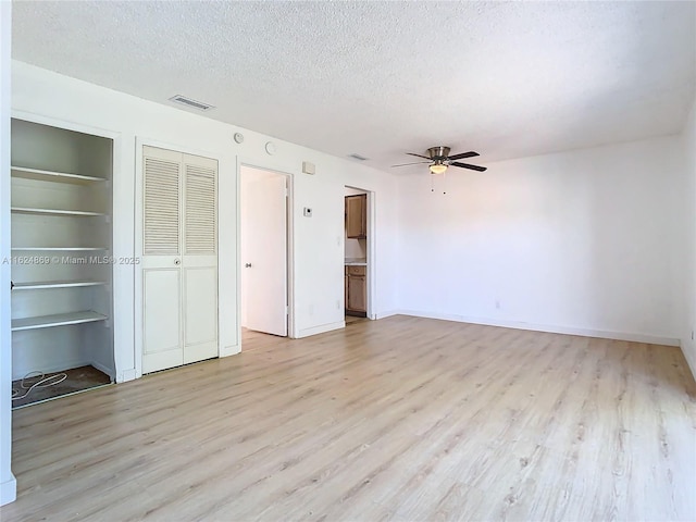 unfurnished bedroom featuring ceiling fan, a textured ceiling, and light wood-type flooring