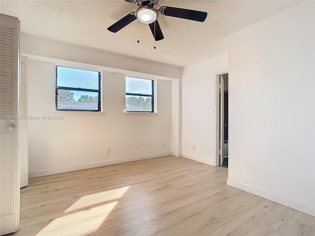 empty room featuring ceiling fan, a textured ceiling, and light hardwood / wood-style flooring