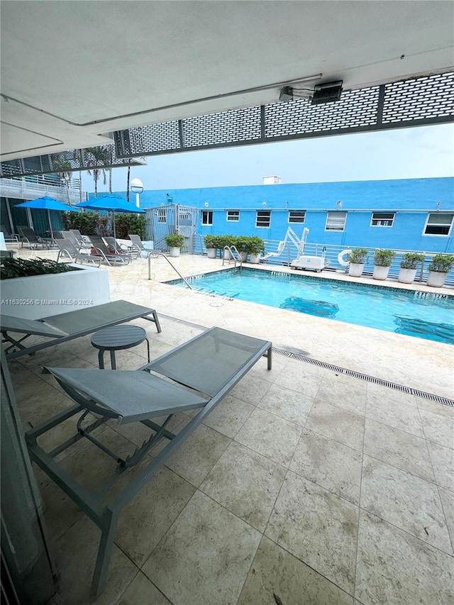 view of swimming pool with a patio and a water view