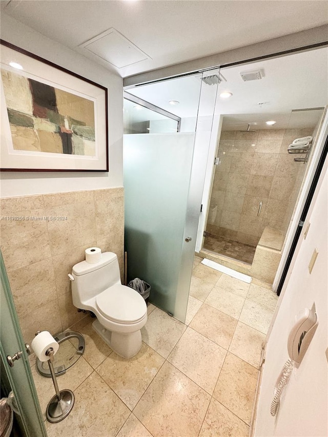 bathroom featuring tile walls, tile patterned flooring, an enclosed shower, and toilet