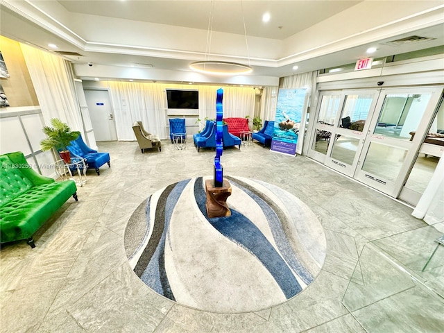 recreation room with a raised ceiling and french doors