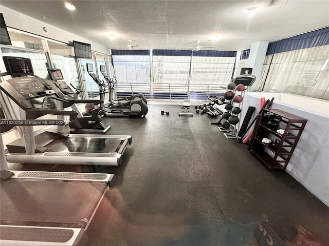 gym featuring ceiling fan and a textured ceiling