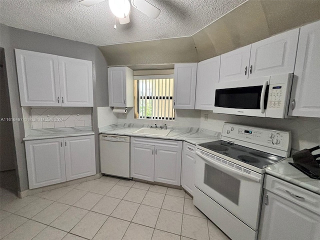 kitchen featuring white appliances, sink, a textured ceiling, white cabinetry, and ceiling fan