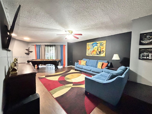 living room featuring a textured ceiling, ceiling fan, hardwood / wood-style floors, and pool table