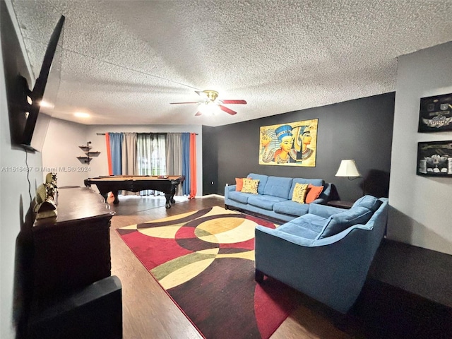 living room featuring pool table, a textured ceiling, hardwood / wood-style flooring, and ceiling fan