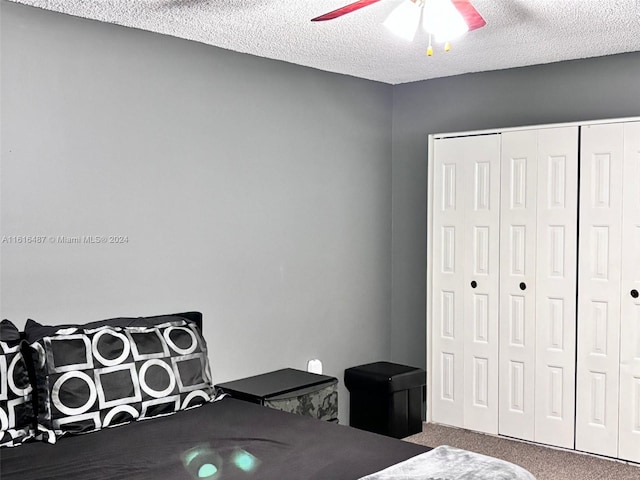 bedroom featuring a closet, carpet floors, a textured ceiling, and ceiling fan