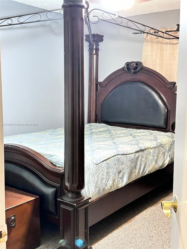 bedroom featuring carpet flooring and a textured ceiling