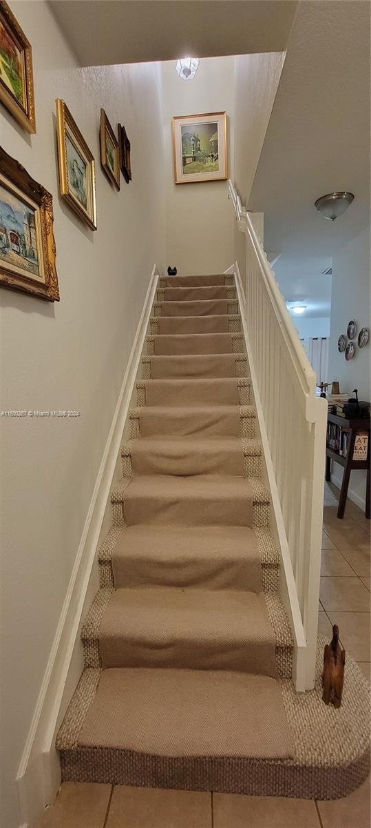 staircase featuring tile patterned flooring