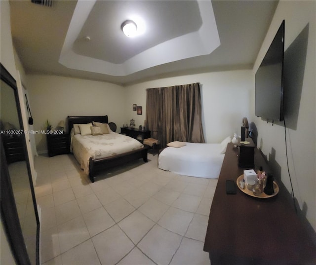 tiled bedroom featuring a tray ceiling