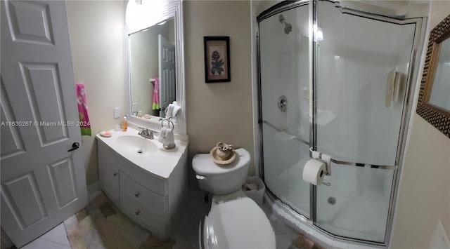 bathroom featuring vanity, toilet, walk in shower, and tile patterned flooring