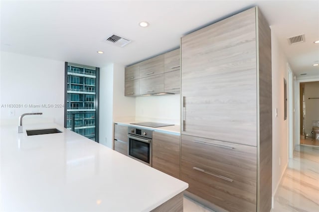 kitchen featuring oven, sink, and black electric stovetop