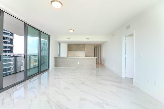 unfurnished room with floor to ceiling windows, a wealth of natural light, and light tile patterned floors