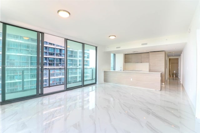 tiled empty room featuring expansive windows