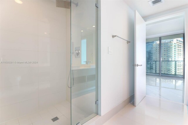 bathroom with an enclosed shower and tile patterned floors