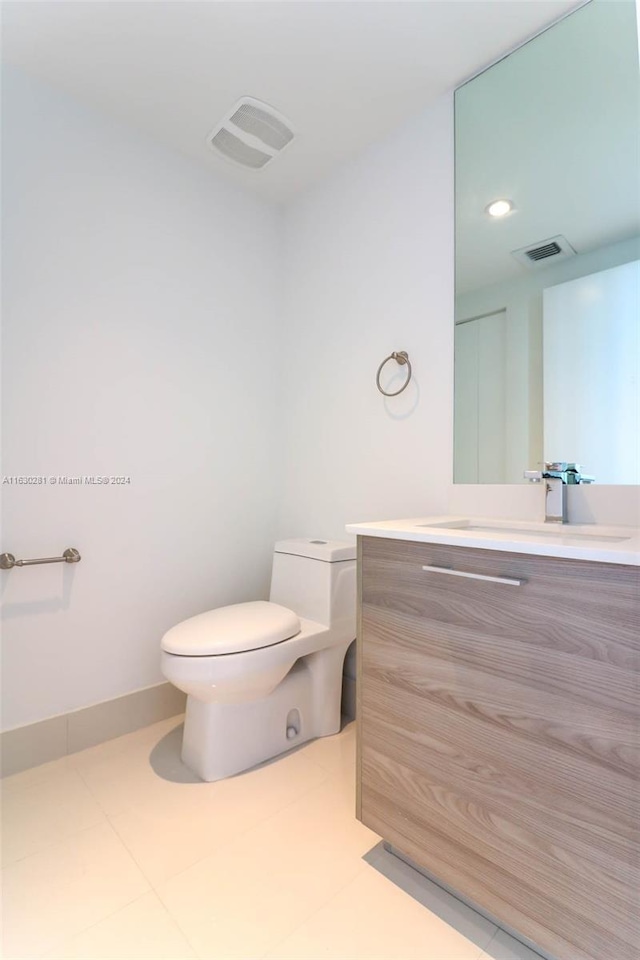 bathroom with vanity, tile patterned flooring, and toilet