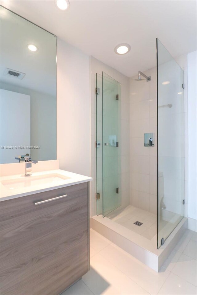 bathroom featuring vanity, an enclosed shower, and tile patterned floors