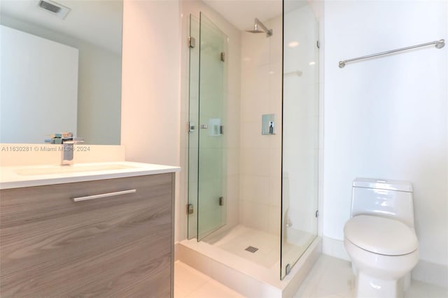 bathroom with tile patterned floors, vanity, an enclosed shower, and toilet